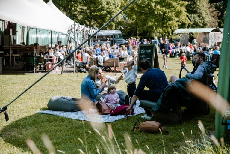 Gezin met kleine kinderen op picknickkleed op Terraseiland kort aan de Klop